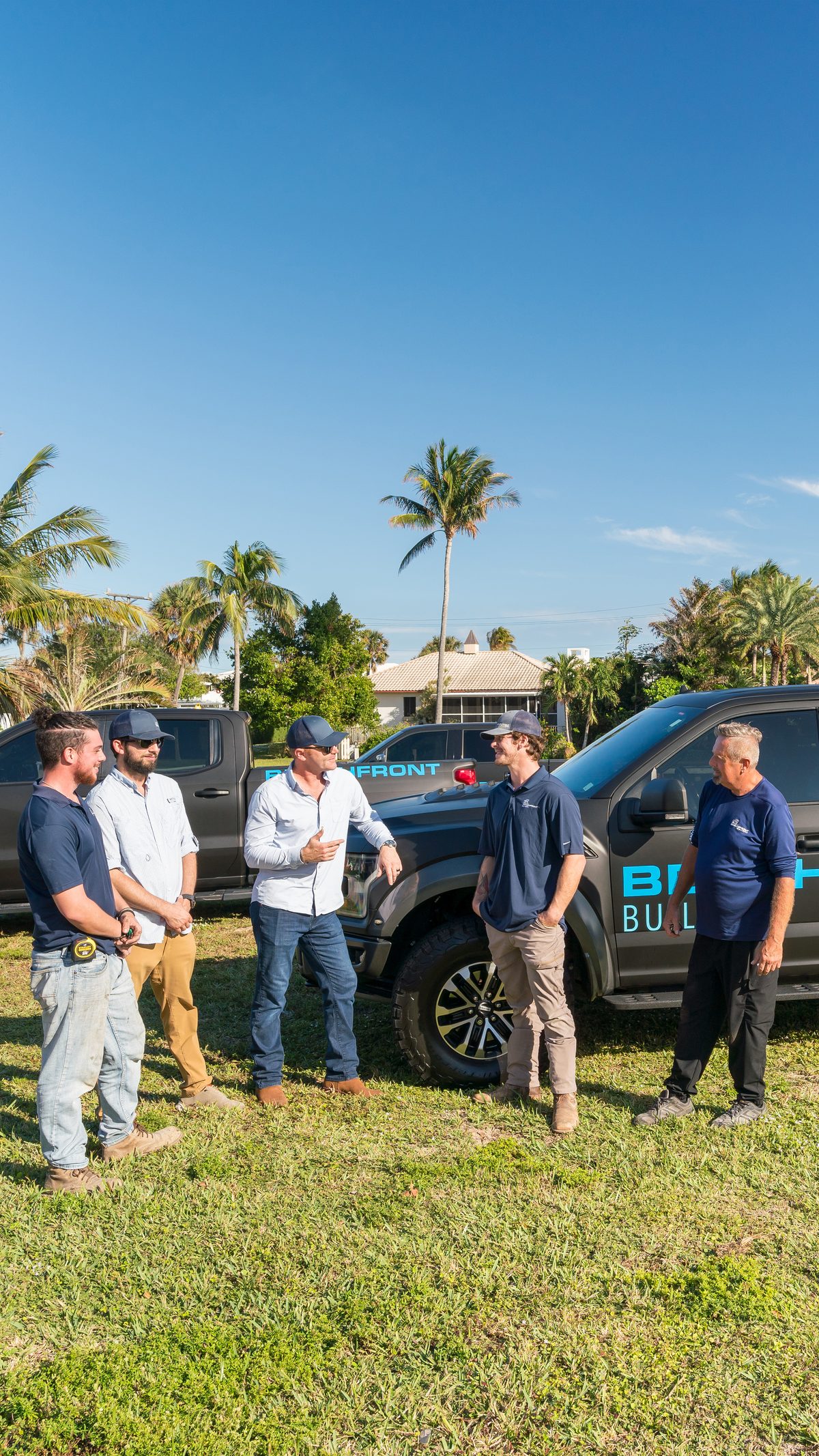 Beachfront Builders field team standing beside the company trucks in Delray Beach